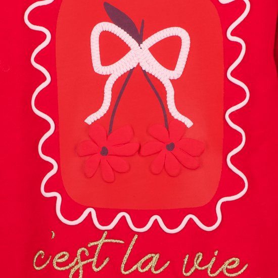 Detail van de print: strik met kersen en bloemen, met 'c'est la vie' tekst.