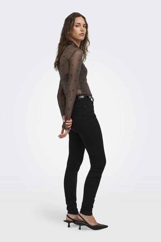 Model van achteren, in bruine mesh top met hartjesprint en zwarte skinny jeans.