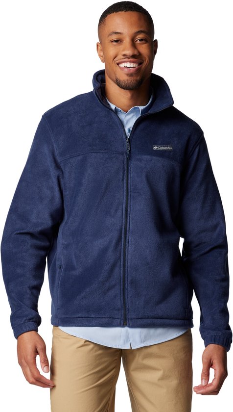Een man draagt een donkerblauwe Columbia fleece jas met volledige ritssluiting en een lichtblauwe blouse eronder.