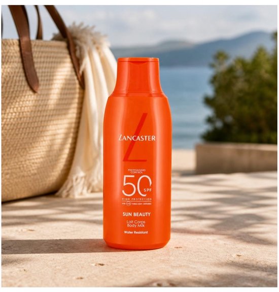 Lancaster Sun Beauty Body Milk SPF50 op een strand met een rieten tas op de achtergrond.