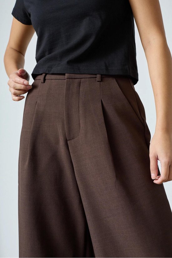 Bruine culottebroek met wijde pijpen, gedragen door een model met een zwarte top.