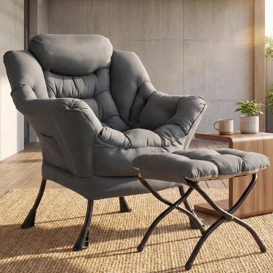 Grijze fauteuil met voetensteun op een gevlochten tapijt, bij een houten tafel met mok en plant.