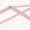 Detail van de roze houten constructie van een kinderhuisbed met schroeven.