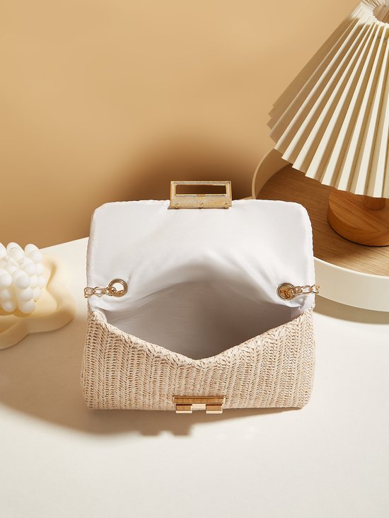 Off-white rieten tas, open met wit interieur en gouden details.
