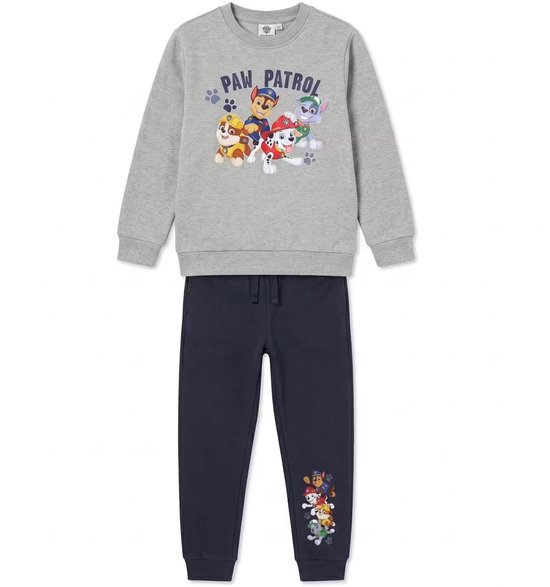 Grijze Paw Patrol sweater met een print van de pups en de tekst "Paw Patrol". Donkerblauwe joggingbroek met een Paw Patrol print op de broekspijp.