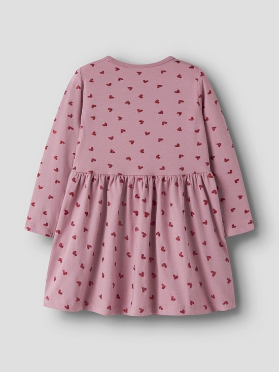 Achterkant van een lichtroze jurk met lange mouwen en een all-over print van rode hartjes. De jurk heeft een ronde hals en een ingesnoerde taille met een zwierige rok.