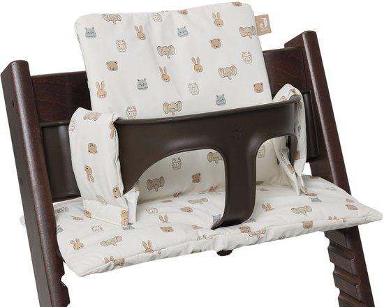 Donkerhouten kinderstoel met een bruin eetblad en crèmekleurige kussens met dierenprint.