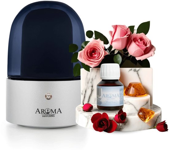 Zilveren aroma diffuser met donkerblauwe kap, met daaromheen roze rozen, rode rozen, ambergroene kristallen op marmeren blokken en een flesje "AROMA DIFFUSING Floral Dream".
