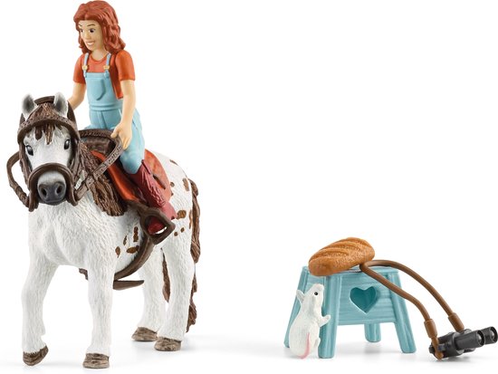 Meisje met rood haar op een witte pony met bruine vlekken, in blauwe tuinbroek en oranje shirt. Naast een poot met brood en een konijn.