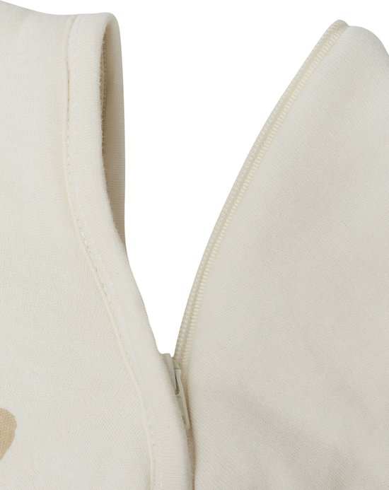 Detail van een off-white slaapzak met teddybeerprint en ritssluiting.