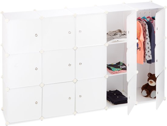 Lange, open witte kledingkast met vakken gevuld met kleding en een teddybeer.