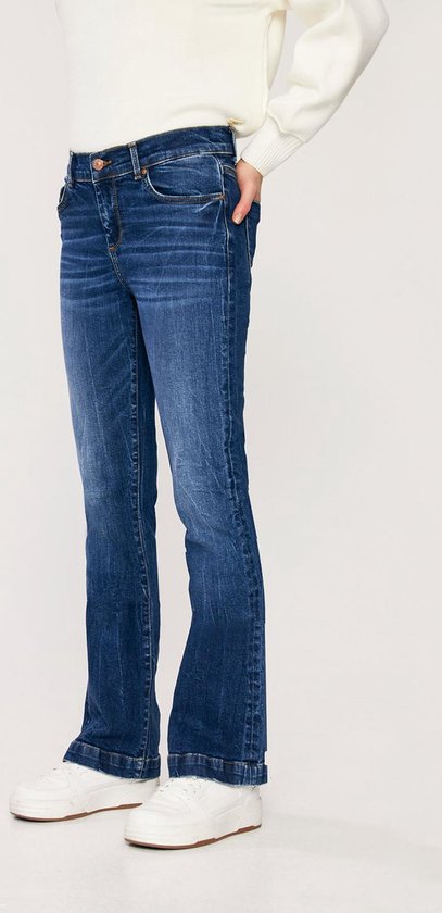 Zijaanzicht van een model in een donkerblauwe flared jeans met een hoge taille en subtiele wassingen.