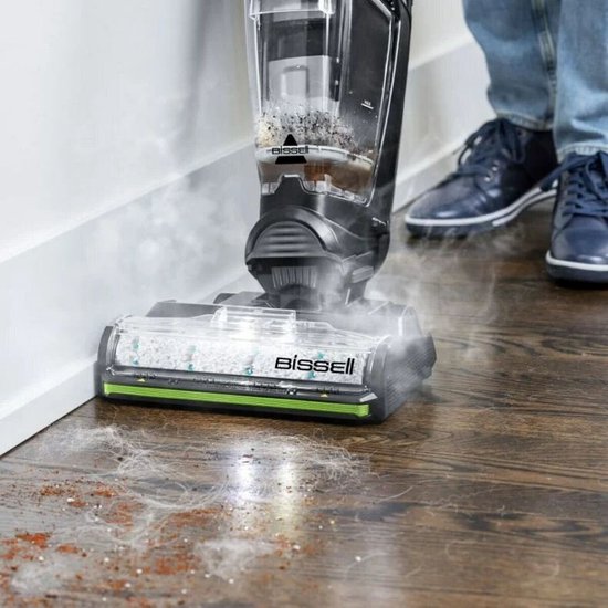 Close-up van de BISSELL HydroSteam stofzuiger die hardnekkig vuil en stof op een houten vloer reinigt met stoom.
