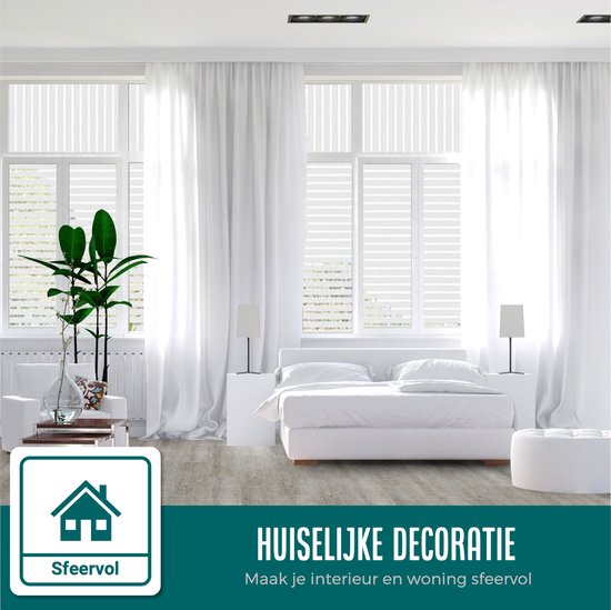 Slaapkamer met gestreept raamfolie, bed, nachtkastjes, lampen en een plant.