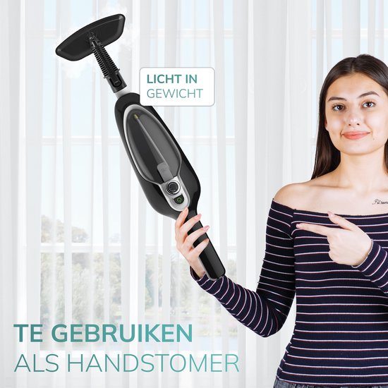 Vrouw met gestreepte top houdt een lichtgewicht, zwarte stoomreiniger met handstoomfunctie vast.