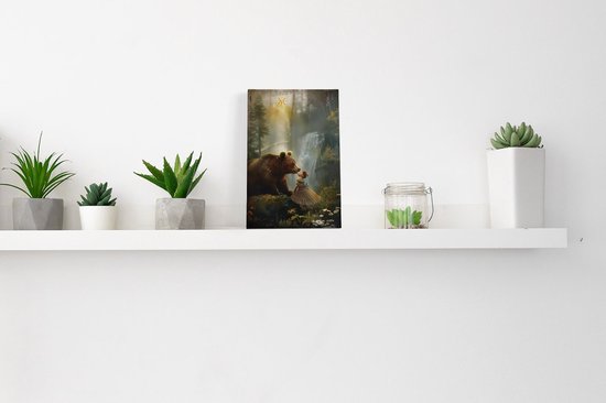 Une peinture d'un ours et d'une fille dans une forêt avec une cascade, placée sur une étagère.