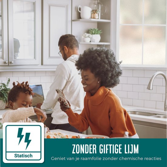 Een gezin in de keuken. De vrouw bekijkt haar telefoon, de man werkt op laptop, kind kijkt mee. Raamfolie is statisch.
