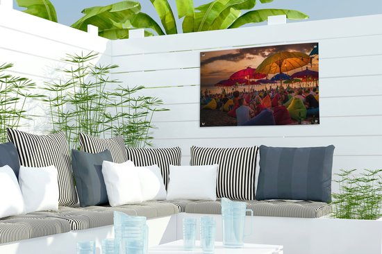 Tuinposter 60x40 cm - Tuindecoratie Toeristen genieten van de zonsondergang bij het strand van Denpasar in Bali, Indonesië - Poster voor in de tuin - Buiten decoratie - Schutting tuinschilderij - Tuindoek muurdecoratie - Wanddecoratie balkondoek
