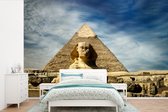 Behang - Fotobehang De Sfinx van Gizeh in Egypte met witte wolken - Breedte 390 cm x hoogte 260 cm