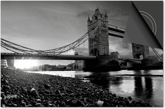 Photo noir et blanc du Tower Bridge à Londres, avec la rivière au premier plan.