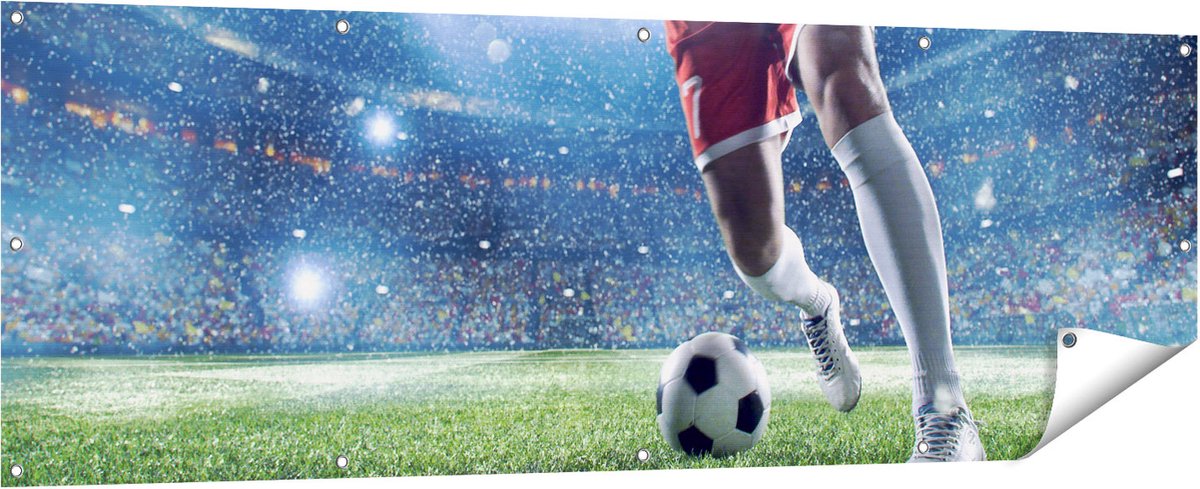 Gards Tuinposter Voetbal Speler met de Bal in een Druk Stadion - 180x60 cm - Tuindoek - Tuindecoratie - Wanddecoratie buiten - Tuinschilderij Multikleur