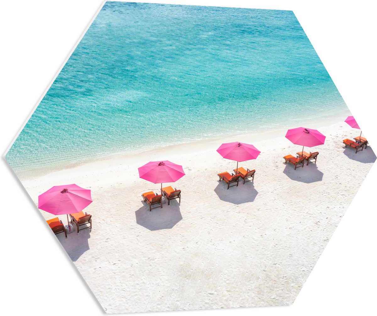 PVC Schuimplaat Hexagon - Ligbedden onder Roze Parasols op het Witte Strand bij Blauwe Oceaan - 80x69.6 cm Foto op Hexagon (Met Ophangsysteem)