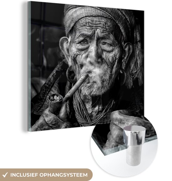 MuchoWow® Glasschilderij 20x20 cm - Schilderij acrylglas - Portret van pijp rokende man met verweerd gezicht in zwart-wit - Foto op glas - Schilderijen