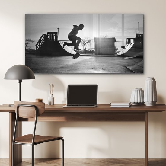Peinture sur verre MuchoWow® - Un garçon fait une cascade avec son skateboard pendant le coucher du soleil - noir et blanc - 120x60 cm - Peintures sur verre acrylique - Photo sur Glas