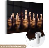 MuchoWow® Glasschilderij 180x120 cm - Schilderij acrylglas - Een schaakspel tegen een zwarte achtergrond - Foto op glas - Schilderijen