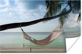 Hangmat vastgeknoopt aan een palmboom bij een strand Poster 180x120 cm - Foto print op Poster (wanddecoratie woonkamer / slaapkamer) / Zee en Strand XXL / Groot formaat!
