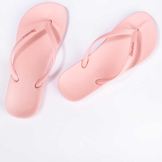 Lichtroze Ipanema slippers met geweven bandjes en een subtiel patroon op de zool.