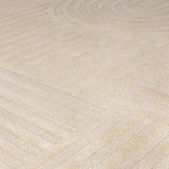 Gedetailleerd zicht op het beige vloerkleed met abstracte cirkels en strakke lijnen.