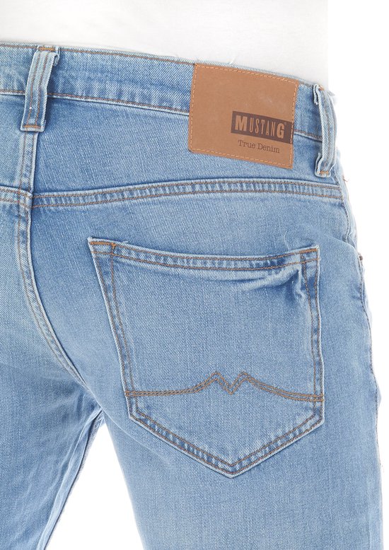Close-up van de achterzak en bruin leren label met Mustang True Denim opschrift.