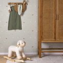 Kinderkamer met 'Little Farm' behang, een houten kast en een schapen-wipper in de kamer.