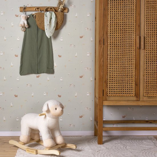 Kinderkamer met 'Little Farm' behang, een houten kast en een schapen-wipper in de kamer.