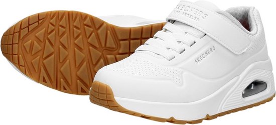 Paar witte Skechers sneakers met klittenbandsluiting, veters en gummi zool, één schoen met profiel.