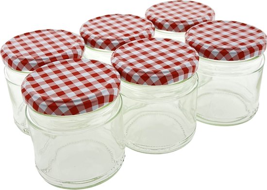 Zes lege glazen confituurpotten met rood-wit geruite deksels.