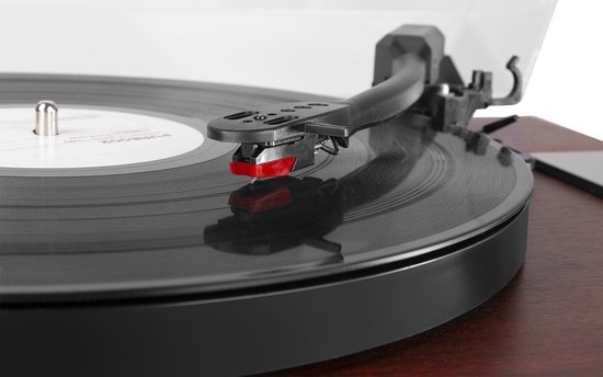 Close-up van de naald van een retro platenspeler die op een vinylplaat rust, met een rode punt op de naald.