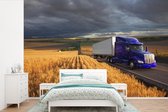 Behang - Fotobehang Paarse vrachtwagen tussen de akkers - Breedte 390 cm x hoogte 260 cm