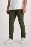 Een man draagt een groene corduroy broek met witte sneakers.