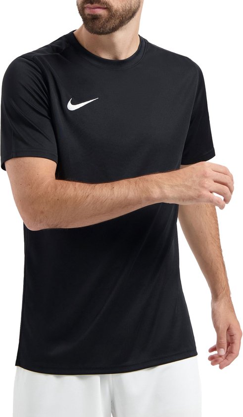 Homme barbu, vu de face, portant un t-shirt de sport noir avec logo Nike blanc et un short blanc.