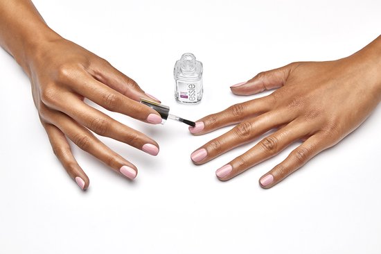 Twee handen met roze nagellak. Eén hand houdt een Essie Speed Setter Top Coat flesje vast, de ander brengt nagellak aan.