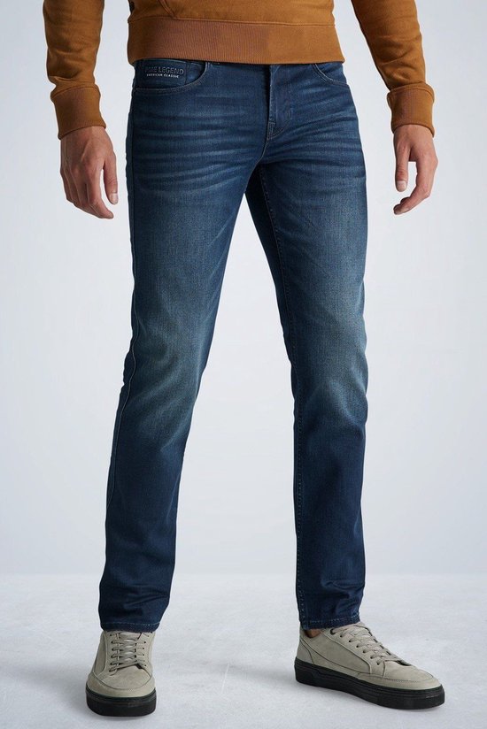 Man met donkerblauwe PME Legend jeans met lichte vervaging op de bovenbenen.