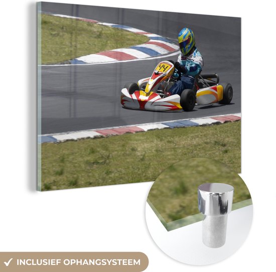 MuchoWow® Glasschilderij 150x100 cm - Schilderij acrylglas - De kartcoureur racet door de bocht op een circuit - Foto op glas - Schilderijen