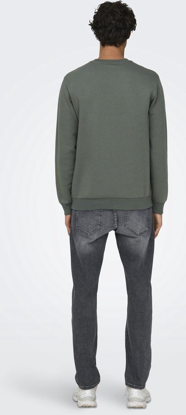 Man draagt een groene trui met lange mouwen en donkergrijze jeans, rugzijde.