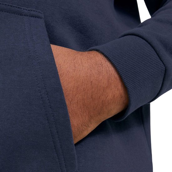 Close-up van een hand die in de zak van een donkerblauwe hoodie wordt gestopt.