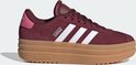 Bordeauxrode Adidas sneakers met witte strepen en een dikke bruine zool.