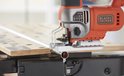 Oranje en zilveren Black+Decker decoupeerzaag met verstelbare snelheid, op een werkbank.