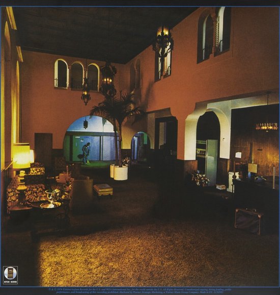 Binnenkant van de hoes van Hotel California, met een lobby in warme kleuren, fontein en palmen.