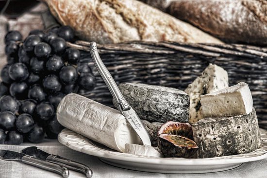 Laguiole kaasmesset met geitenkaas, blauwschimmelkaas, druiven en brood in mand.